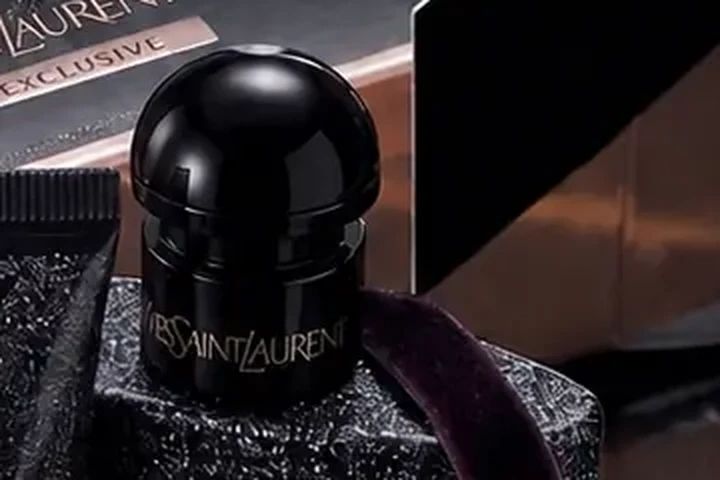 Close detail of the lacquered black cap and engraved shoulder of the Black Opium bottle